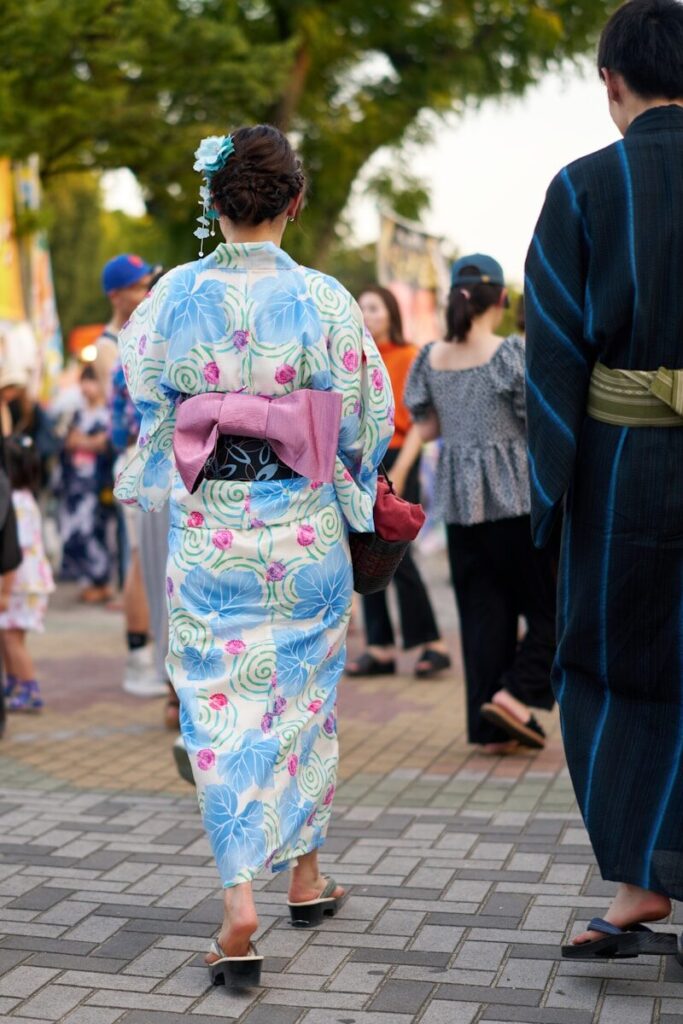 うちわを帯にさした浴衣の女性